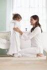 Donna avvolgente figlia in asciugamano dopo il bagno — Foto stock