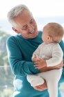 Feliz abuelo con nieta bebé - foto de stock