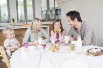 Família feliz se divertindo na mesa de café da manhã — Fotografia de Stock