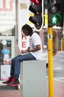 Homem usando laptop perto do semáforo na cidade — Fotografia de Stock