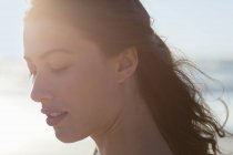Close-up of thoughtful young woman with eyes closed on beach — Stock Photo