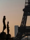 France, Paris, deux statues en bronze coloré (1937) sur l'esplanade Trocad ? ro avec la Tour Eiffel et la Tour Montparnasse au crépuscule — Photo de stock