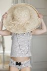 Cute little girl wearing oversized straw hat — Stock Photo