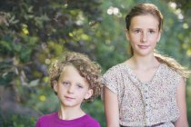 Портрет милий братів і сестер, що стояли разом в літньому саду — стокове фото