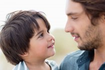 Close-up of a man and his son looking at each other — Stock Photo