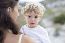 Close-up of cute baby boy in mother hands outdoors — Stock Photo