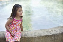 Kleines Mädchen sitzt am Rand des Schwimmbades — Stockfoto