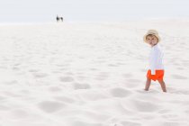 Carino bambino in piedi sulla spiaggia di sabbia — Foto stock
