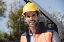 Portrait of smiling male engineer standing at van — Stock Photo
