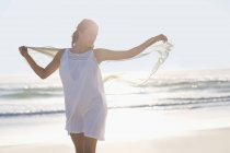 Rilassato giovane donna con le braccia tese godendo sulla spiaggia — Foto stock