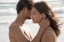 Молода пара Роман на пляжі з хвилястим моря на тлі — стокове фото