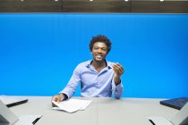 Empresário fazendo papelada e sorrindo na sala de conferências — Fotografia de Stock
