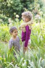 Portrait of smiling boy standing with little girl in meadow — Stock Photo