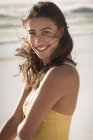 Retrato de jovem mulher feliz em pé na praia — Fotografia de Stock