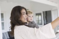 Elegante madre y lindo hijo tomando selfie en casa — Stock Photo