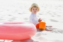 Menino de chapéu de palha brincando na praia de areia — Fotografia de Stock