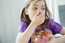 Bambina che tiene la scatola piena di caramelle gommose — Foto stock