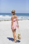 Вид спереду молода струнка жінка, що йде на піщаному пляжі — стокове фото