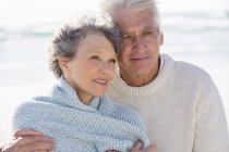 Gros plan d'un couple de personnes âgées réfléchies embrassant sur la plage — Photo de stock
