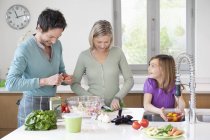 Famille heureuse préparant la nourriture dans la cuisine — Photo de stock