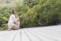 Happy mother and son on deck in garden — Stock Photo