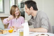 Man eating breakfast with daughter in kitchen — Stock Photo
