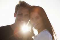 Portrait de couple heureux souriant dans rétro-éclairé — Photo de stock