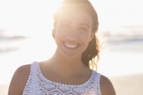 Portrait de jeune femme souriante sur une plage ensoleillée — Photo de stock