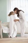 Mulher esfregando narizes com a filha envolto em toalha após o banho — Fotografia de Stock