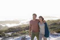 Relaxed romantic couple walking on coast together — Stock Photo