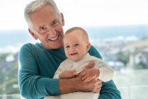 Retrato de abuelo feliz con nieta bebé - foto de stock
