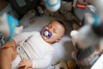 8 meses niño llorando en su cama - foto de stock