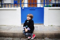 Kleiner Junge sitzt auf dem Gehweg — Stockfoto