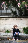 Menino sentado na calçada — Fotografia de Stock