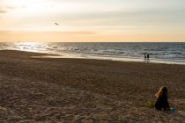 Франция, Норильск, маленькая девочка, играющая на пляже на закате — стоковое фото