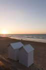 Francia, Normandía, cabañas de playa en la playa al atardecer - foto de stock