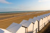 France, Normandie, cabanes de plage blanches en ligne sur le sable — Photo de stock