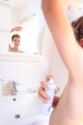 France, young boy in the bathroom using spray. — Stock Photo