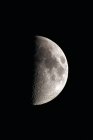 Primer plano de la luna del primer cuarto sobre fondo negro - foto de stock