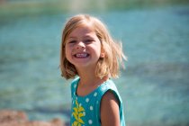 Portrait of a very pretty little girl smiling behing the sea. — Stock Photo
