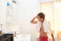 Francia, giovane ragazzo in bagno che si guarda allo specchio. — Foto stock