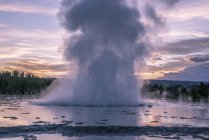Splashing geyser at sunset, Yellowstone National Park, Wyoming, Estados Unidos de América, Norteamérica - foto de stock