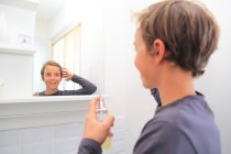 Франція, підліток у ванній кімнаті, користується парфумом.. — стокове фото