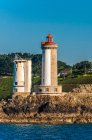 Francia, Bretaña, Goulet de Brest, Plouzane, faro Petit Minou (1848) y antigua torre de radar del semáforo de la marina nacional (campo militar) - foto de stock