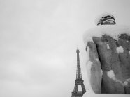 France, Paris, 16th arrondissement, snowy statue of man at Trocadero turns towards the Eiffel tower / Snow covered man statue facing Eiffel tower, 16th arrondissement, Paris, France — Photo de stock