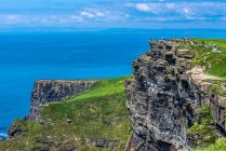 Europa, República de Irlanda, Condado de Galway, Islas Aran, Isla Inishmore, acantilados excavados junto al mar cerca del sitio prehistórico de Dun Aengus Ringfort (Aonghasa) (1100 a.C. - 800 d.C.) - foto de stock