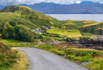 Europa, Gran Bretaña, Escocia, Hébridas, al sureste de la Isla de Skye, carretera y granja con su recinto en Point of Sleat - foto de stock