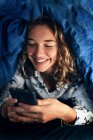 Teenager-Mädchen und der Alltag. Mit Smartphone im Bett — Stockfoto