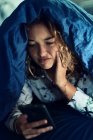Teenage girl and everyday life. In bed with smartphone — Stock Photo