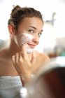 Teenage girl with face mask in bathroom — Stock Photo